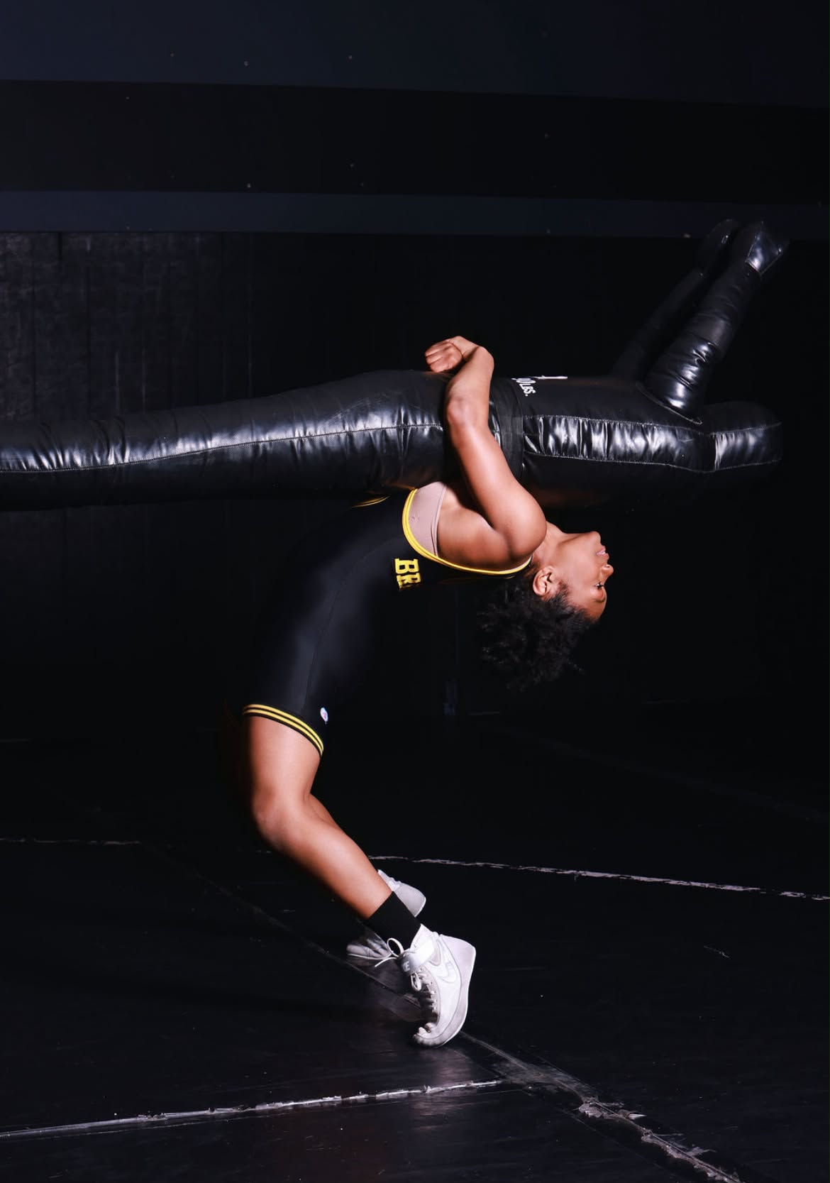Tamara Humphries arched backwards over a training dummy in a darkened wrestling room.